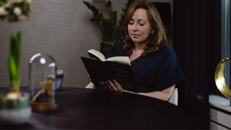 Claudia Bastiaansen leest een boek aan tafel
