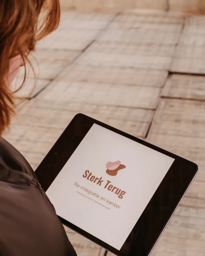 Claudia Bastiaansen bekijkt de pagina van Sterk Terug op een tablet