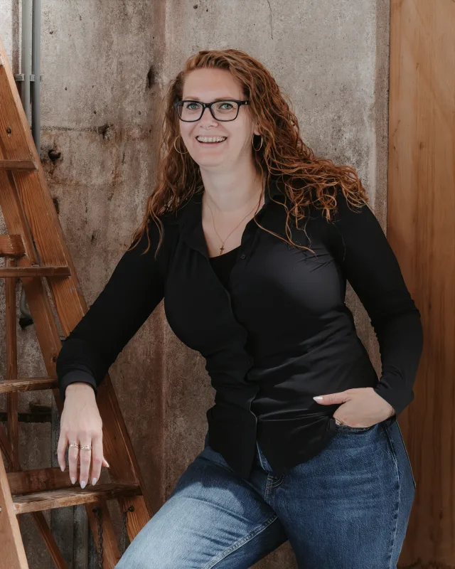 Ina Mulder leunend tegen een houten ladder